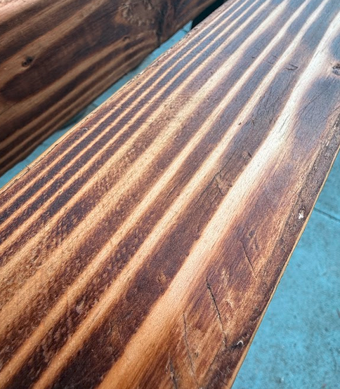 Close macro shot of yakisugi grain after sanding and teak oil — rich wood texture